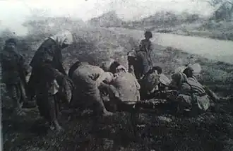 Armenian refugees collected near the body of a dead horse at Deir ez-Zor, during the Armenian genocide