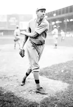 A black and white image of a man following through after throwing a baseball with his left hand