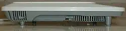Ventilation slots visible. The unit has a small depth compared to the width of the stove.