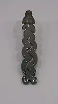 A jade carving of a bird (possibly a quetzal) with long tail feathers