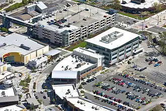 Aerial view of several mid-rise buildings surrounded by parking lots and a parking garage