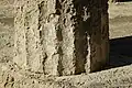 A Doric column drum from the L-shaped stoa resting on the stylobate; plaster is visible.