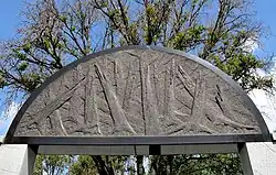 A syenitic block above the entrance with a symbol of shattered trees.