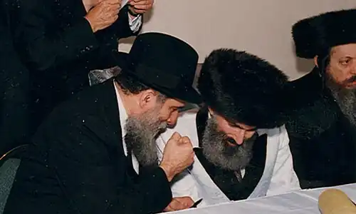 Two rabbis talking, with a third on the right